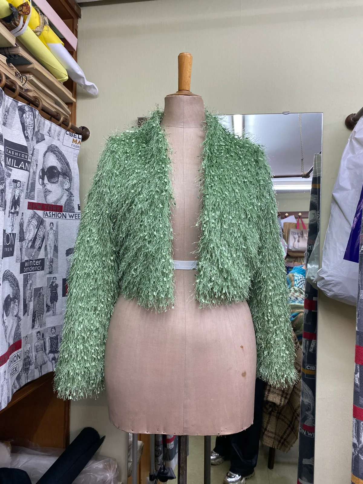 Vista frontal de la Chaqueta Césped verde de textura con flecos sobre maniquí