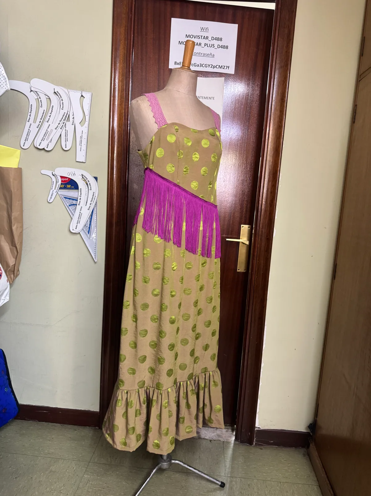 Vestido Oliva largo sobre maniquí, con motivos circulares y flecos en contraste